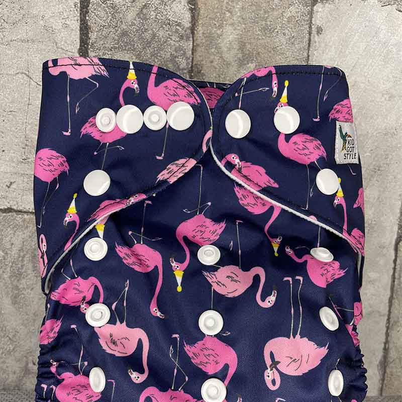 Front view of a navy reusable nappy with pink flamingos wearing party hats