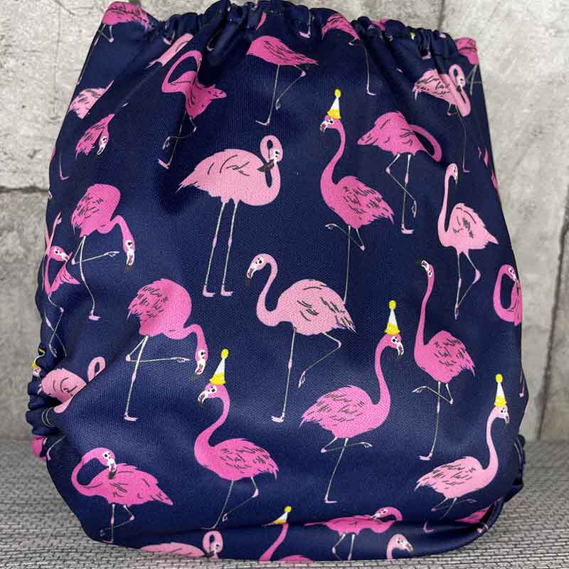 Back view of a navy reusable nappy with pink flamingos wearing party hats