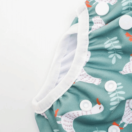 Close up of a reusable swimming nappy with geese on a sage background
