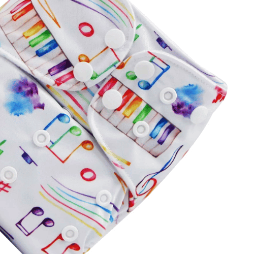 Close up of a cloth nappy with multi-coloured music notes on a white background