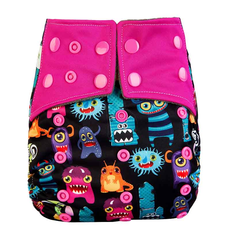 Close up a reusable diaper with pink wings and a colourful monsters patter